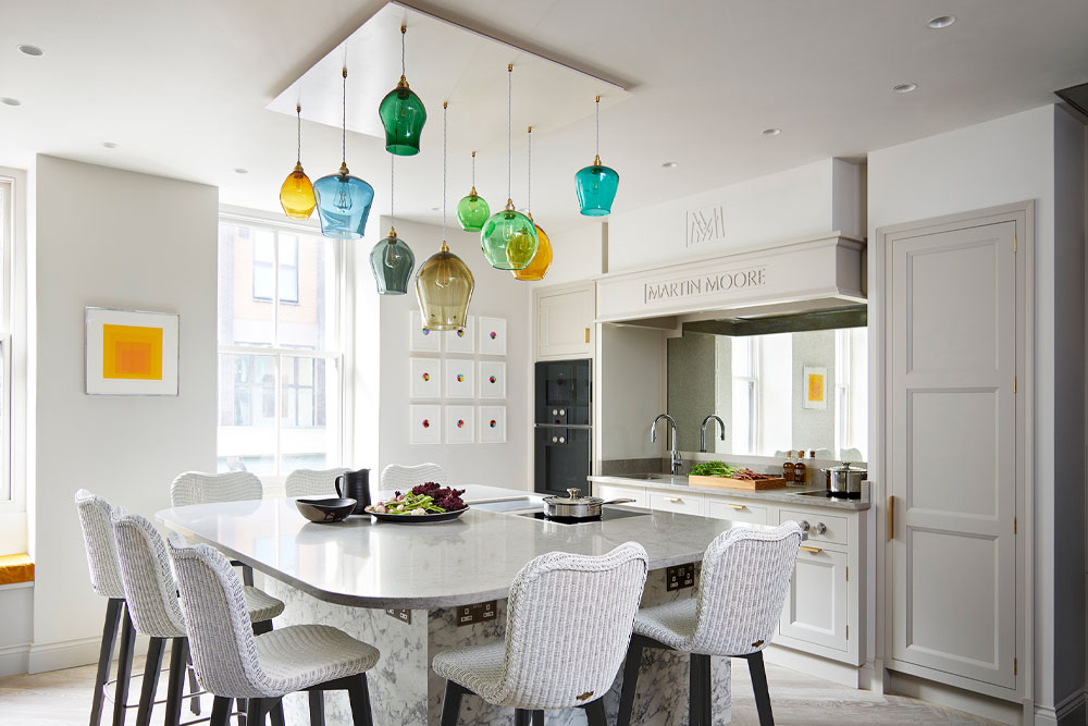 Statement green and blue hand-blown glass pendant chandelier over large kitchen island in the showcase kitchen of Michelin starred restaurant Pied à Terre.