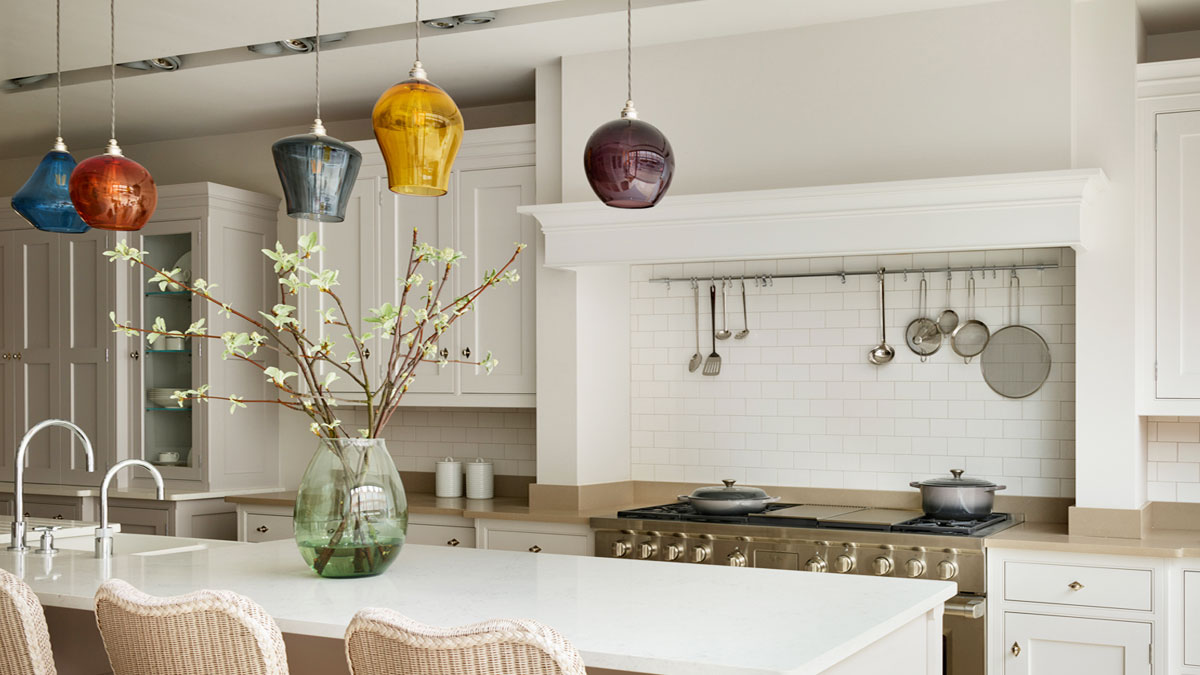 Ecclectic collection of colourful hand-bown glass pendant lights over a contemporary kitchen island.